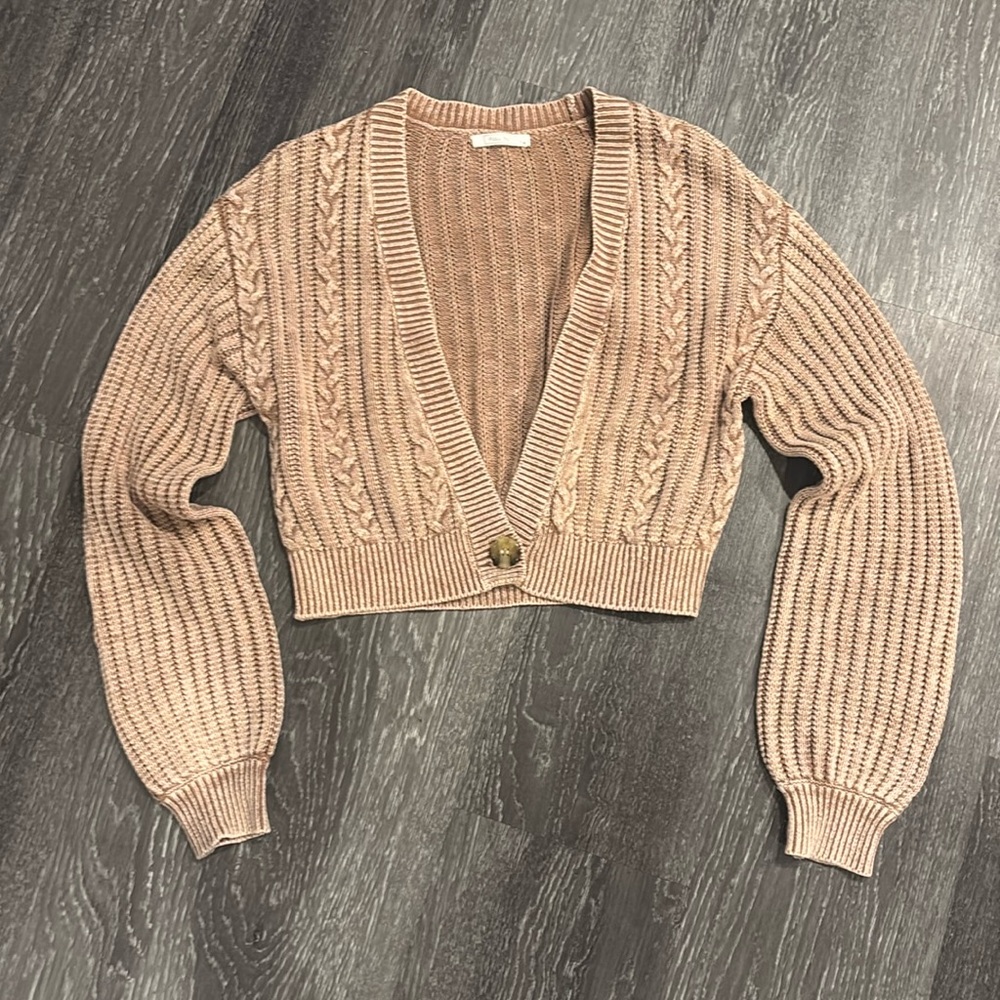 Rosey cream colored cardigann with one button on the bottom.